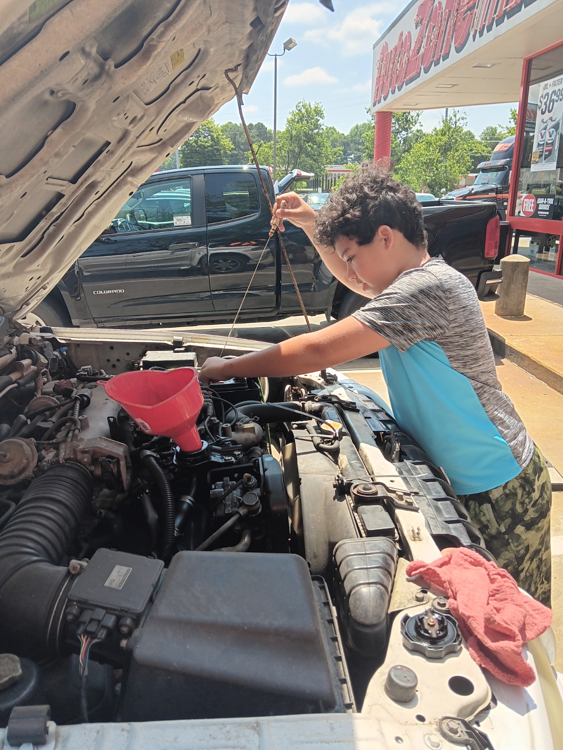 Checking engine oil under the hood of a vehicle